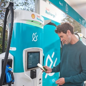 Man using phone at a Shell Recharge Station