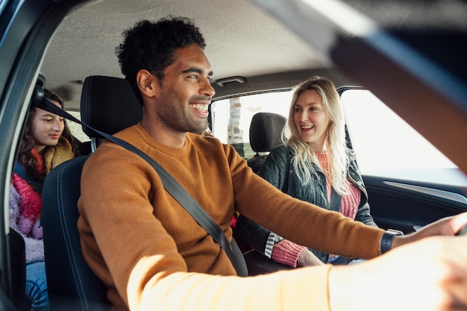 Family in car driving and smiling