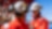 A worker in red coveralls with a Shell logo talks to a colleague.