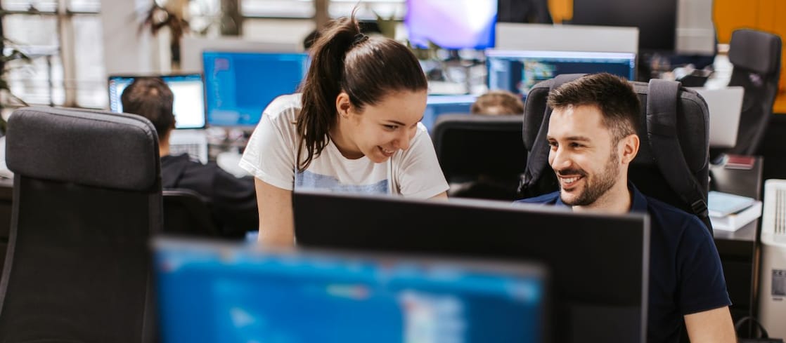 Two colleagues collaborating at a computer workstation in a office