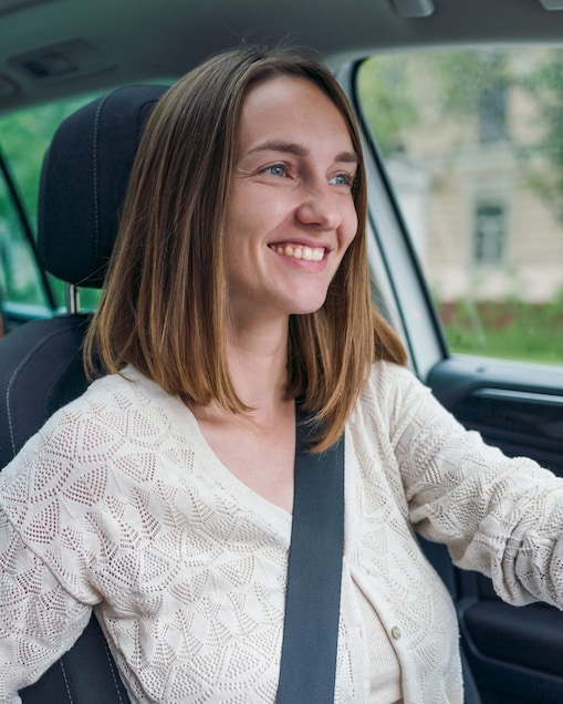 Happy mother driving baby in back carseat