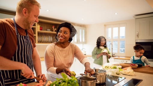 A family hanging out together in the kitchen, making tea together.