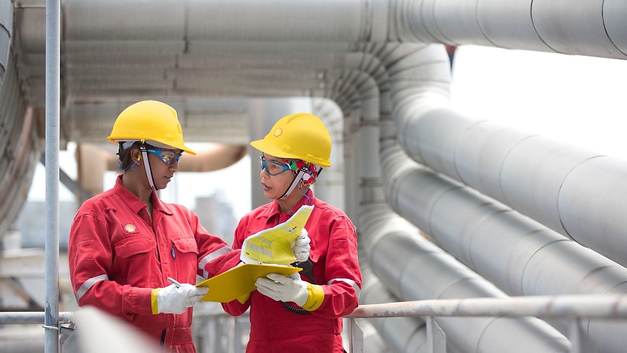 two workers discussing a project in a refinery in Malaysia
