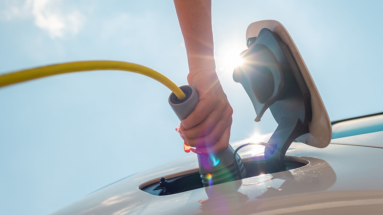 Hand charging electric car with charger cable