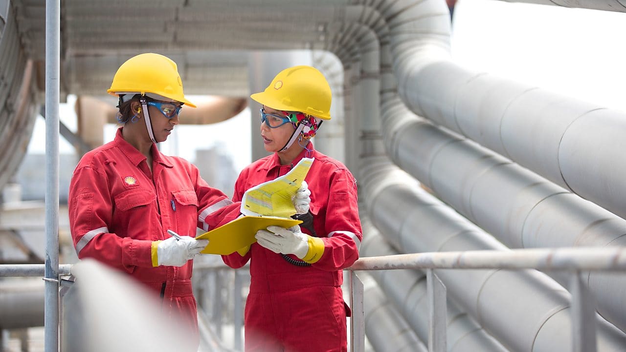 two workers discussing a project in a refinery in Malaysia