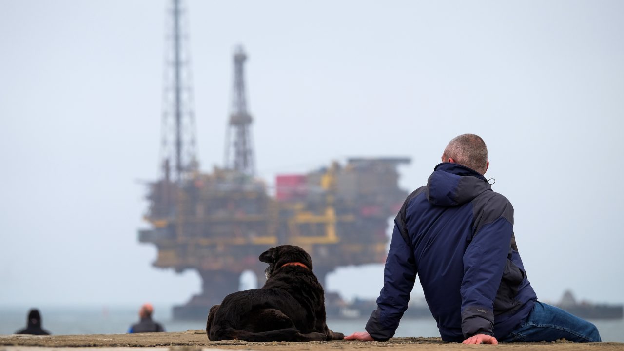 One man and his dog marvel at the scale of Brent Delta passing by