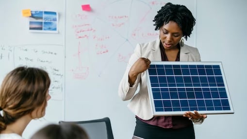 Teacher holding a solar panel and explaining to a class