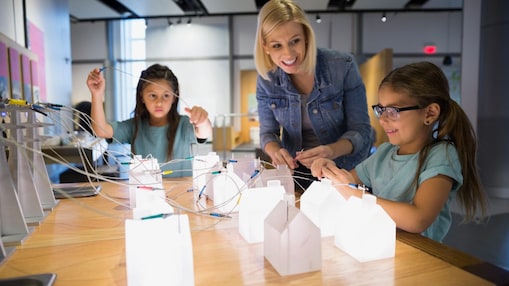 Family playing with electricity grid exhibit science center