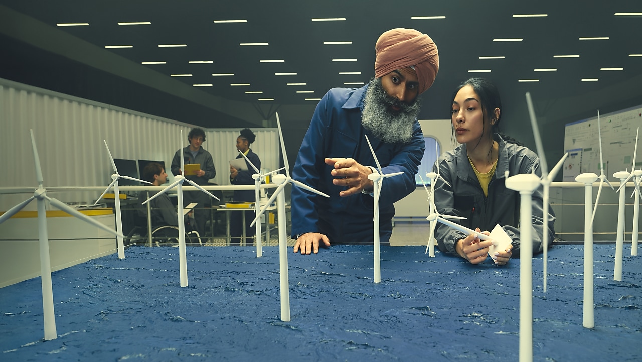 man pointing at wind turbine