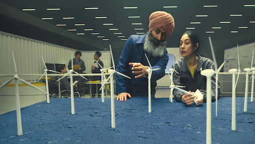 man pointing at wind turbine