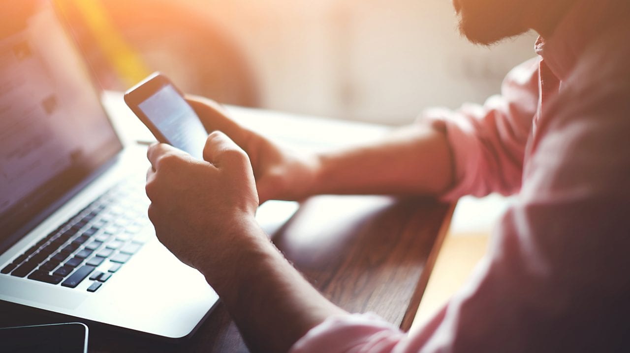 Man with phone and laptop
