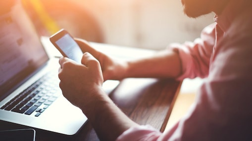 Man with phone and laptop