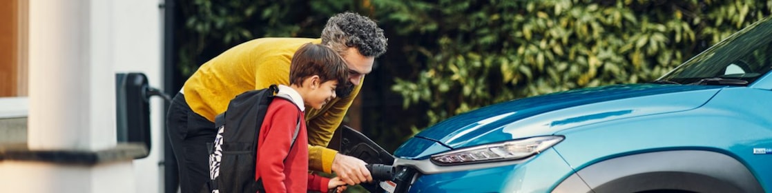 father and son with ev charger