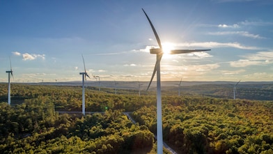Wind Turbine Generators on a mountain in the setting sun.