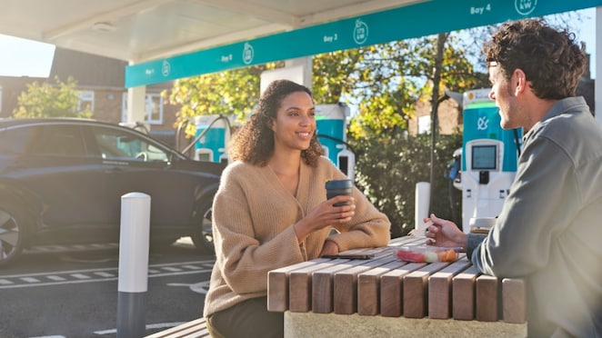 Woman and man having breakfast at shell recharge station