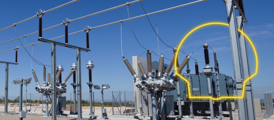 A photograph of a transformer with the sun rising behind it.