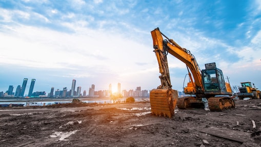 Excavator in a construction site with the city in background