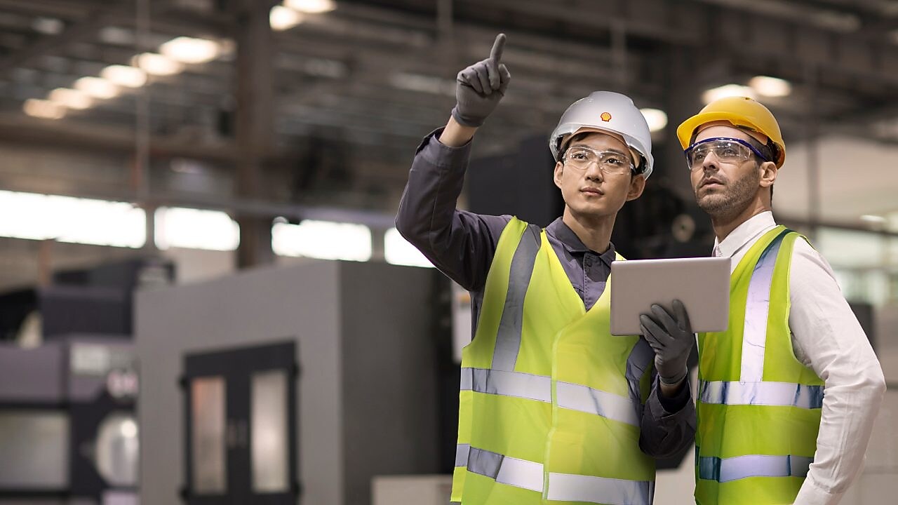 Two engineers in hard hats assessing