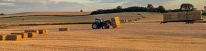 Farmer collecting hale bales with a tractor on his farm