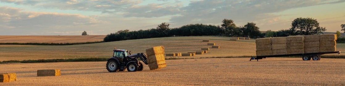 Farmer collecting hale bales with a tractor on his farm