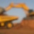 Digger dumping earth into a dump truck