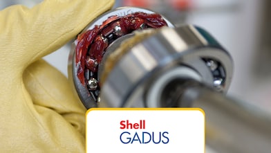 Closed up macro, ball bearing put into yellow transparent lithium grease isolated on white background with copy space, engineering and industrial concept