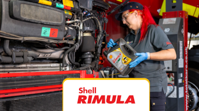 In auto repair shop – pouring oil into a truck.