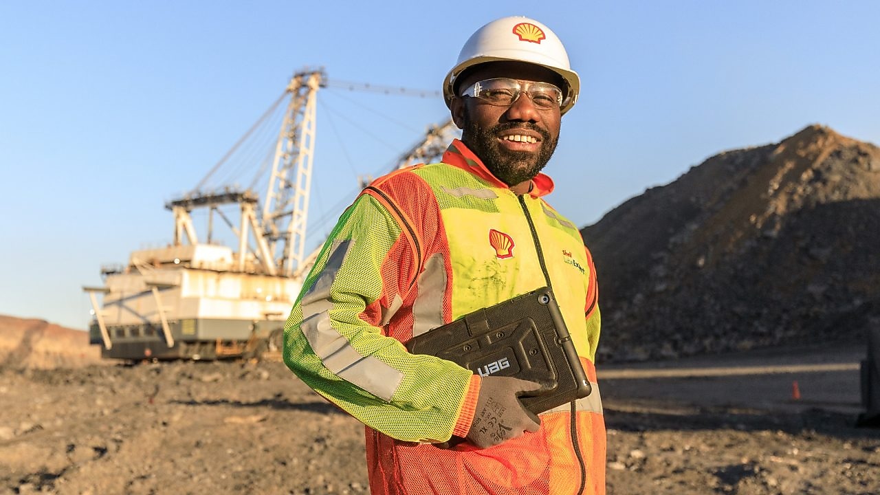 Shell engineer carrying documents across a mine