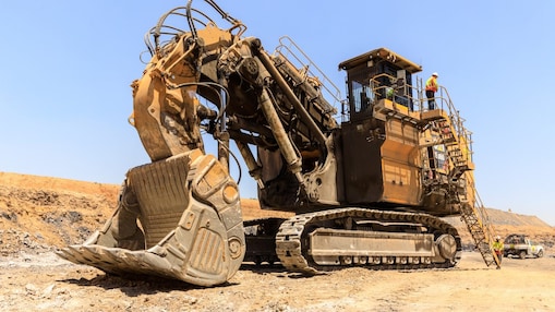 Large excavator in a mine with engineers working on it