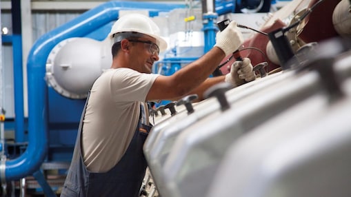 Engineer in hard hat fixing machine