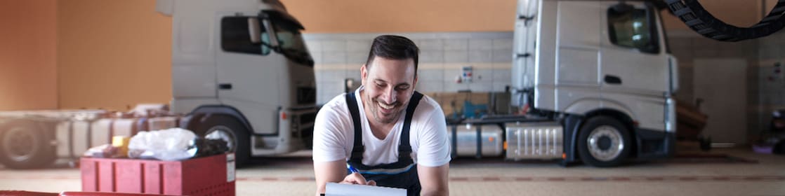 Truck mechanics doing paperwork before vehicle service in truck repair shop