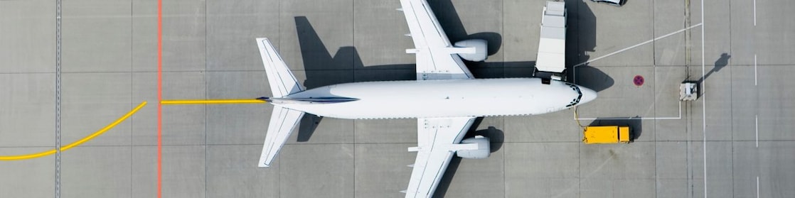 Arial view of the top of a passenger airplane on the tarmac being filled up with fuel