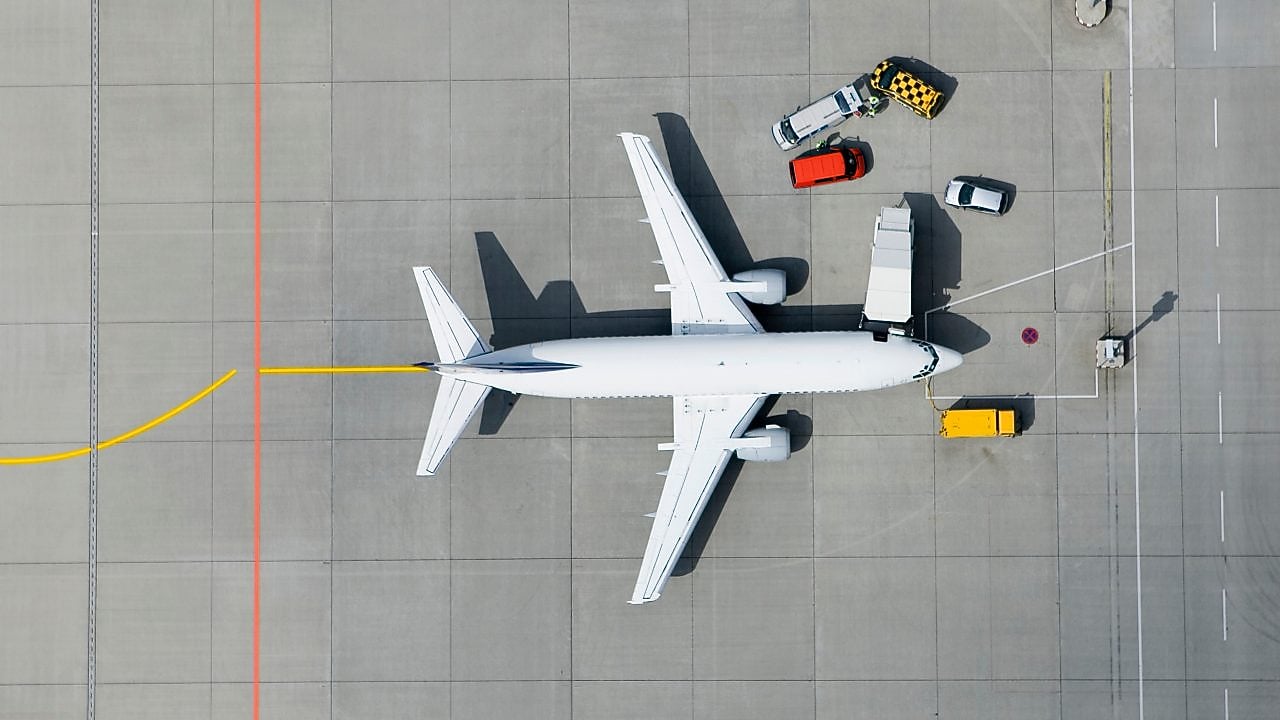 Arial view of the top of a passenger airplane on the tarmac being filled up with fuel