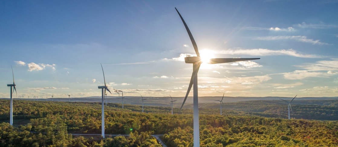 Wind Turbine Generators on a mountain in the setting sun.