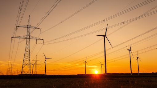 Wind energy generation connected to the electricity transmission network at sunset.
