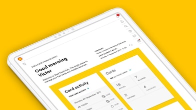 Angled view of a tablet on a yellow background displaying a dashboard interface with greeting text and card activity panels.
