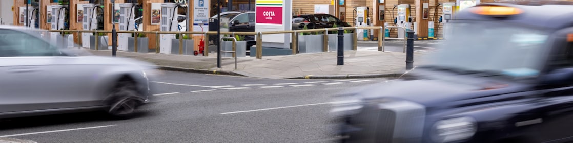 black cab driving by shell fuel station