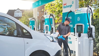 Person charging white van at Shell Recharge electric vehicle charging station