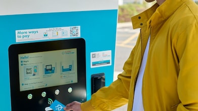 A man using a Shell Recharge electric vehicle charging station