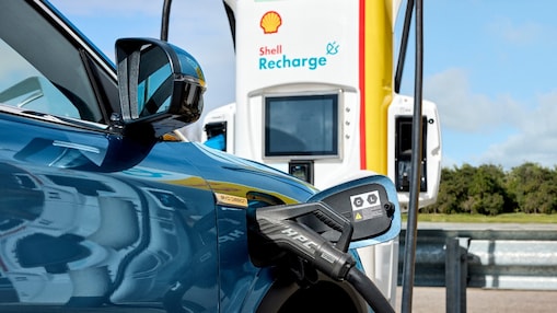 A blue car parked at a Shell Recharge station charging
