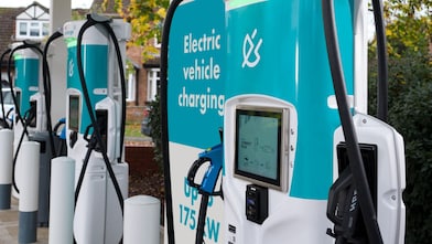 Electric vehicle charging stations with teal and white colour, featuring digital screens and charging cables