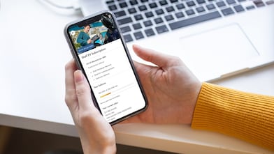 A person holding a phone,  open on the Shell App