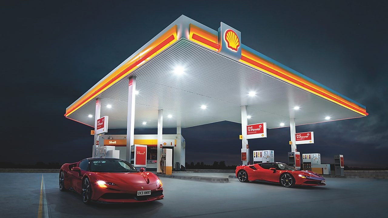 Two red Ferraris parked on a Shell Forecourt at night