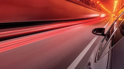 Side view of a car driving in the night