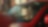 The image shows a close up of a man in the driving seat of a red vehicle, holding the steering wheel. A reflection at the top of the windscreen shows a Shell V-Power sign, and to the left of the car, there is a partial view of a digital forecourt screen, showing the Shell Pecten (logo).