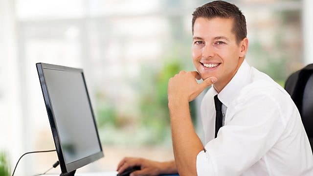 Man working on computer and smiling