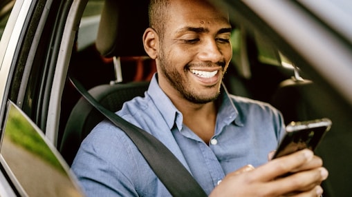 Man looking at his phone in a stationary car